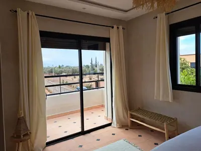 a bedroom with a large glass door with a balcony at Villa Rahma in Marrakech