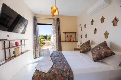 a bedroom with a bed and a tv and a window at Stylish hôtel in Marrakech