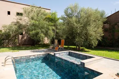 a swimming pool in a yard with trees at Stylish hôtel in Marrakech