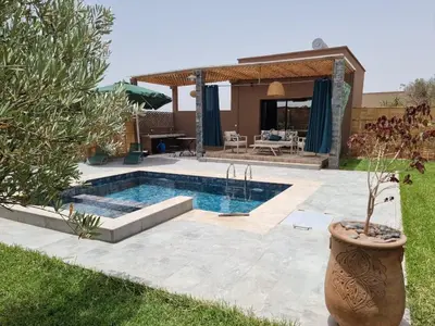 a swimming pool in a yard with a house at Stylish hôtel in Marrakech