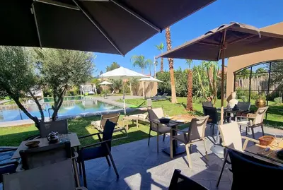 a patio with tables and chairs and a pool at Stylish hôtel in Marrakech
