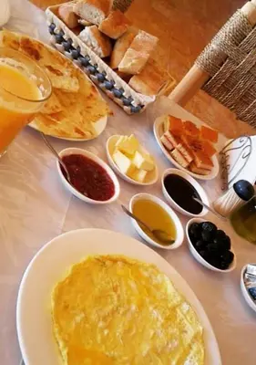 a table with a plate of breakfast food and bread at Sahara mirage camp in Merzouga