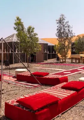 a group of red pillows sitting on the ground at Sahara mirage camp in Merzouga