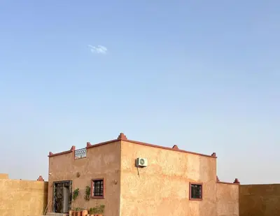 an old building in the desert with the sky in the background at Merzouga Dunes Apartment in Merzouga
