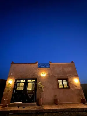 a building with blue lights on the side of it at Merzouga Dunes Apartment in Merzouga