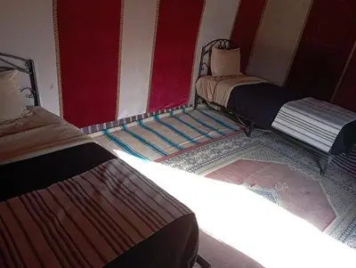 a group of three beds in a room at Mars Desert Camp Merzouga in Merzouga