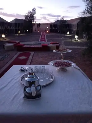 a table with a white table cloth with glasses on it at Mars Desert Camp Merzouga in Merzouga