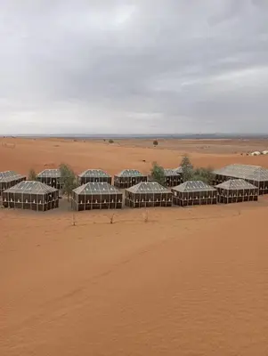 a group of huts in the middle of a desert at Mars Desert Camp Merzouga in Merzouga