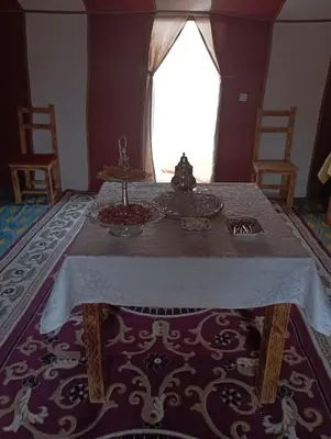 a dining room with a table with a white table cloth at Mars Desert Camp Merzouga in Merzouga