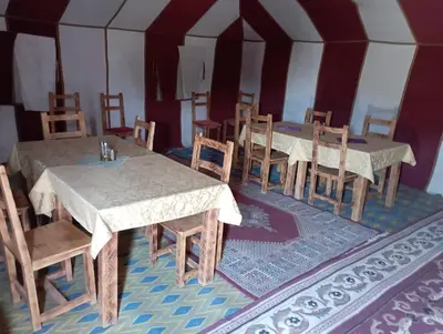 a dining room with tables and chairs in a tent at Mars Desert Camp Merzouga in Merzouga