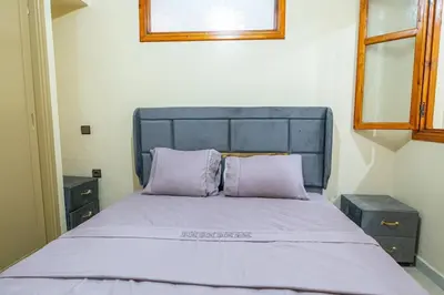 a bedroom with a bed with purple pillows and a window at Bab Atas appartment N4 in Ourika Valley in Marrakech
