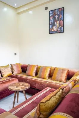 a living room with a couch with pillows and a table at Bab Atas appartment N4 in Ourika Valley in Marrakech