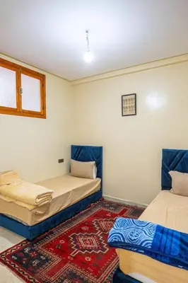 a room with two beds and a rug at Bab Atas appartment N4 in Ourika Valley in Marrakech
