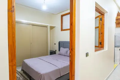 a small bedroom with a bed and a mirror at Bab Atas appartment N4 in Ourika Valley in Marrakech