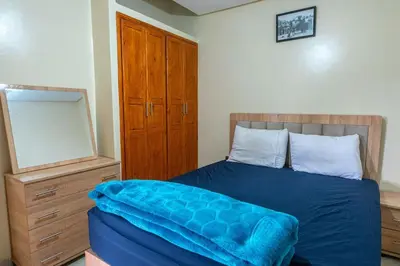 a bedroom with a bed with a blue blanket on it at Bab Atlas appartment N3 in Ourika valley in Aghbalou