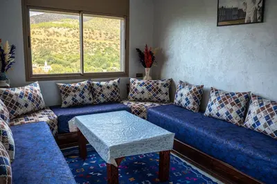 a living room with blue couches and a table at Bab Atlas appartment N3 in Ourika valley in Aghbalou
