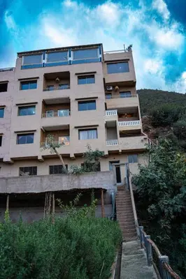 a tall building with stairs leading up to it at Bab Atlas appartment N5 in Ourika valley in Aghbalou
