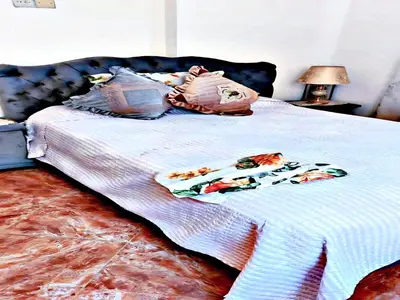 a bed with a white blanket and pillows on it at Luxury 3-bedroom apartments 5-min to the Airport in Fès