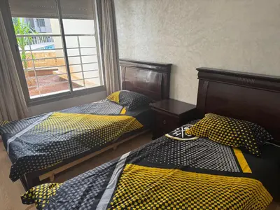 two twin beds in a room with a window at Luxury appartement prestigia avec wifi fibre optique in Fès