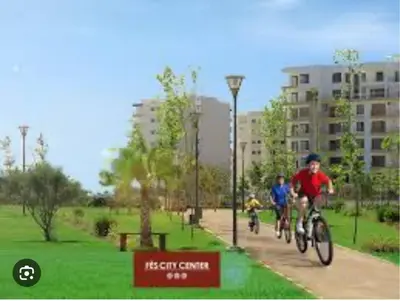two people riding bikes down a path in a park at Luxury appartement prestigia avec wifi fibre optique in Fès