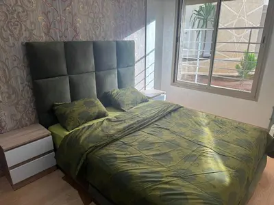 a bedroom with a bed with a headboard and a window at Luxury appartement prestigia avec wifi fibre optique in Fès