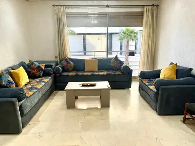 a living room with a blue couch and a table at Luxury appartement prestigia avec wifi fibre optique in Fès