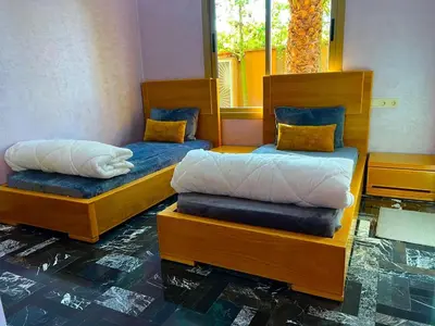 a room with two beds and a mirror at Villa avec piscine et jardin in Marrakech