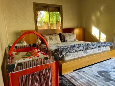 a bedroom with a bed and a crib at Villa avec piscine et jardin in Marrakech