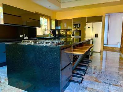 a large kitchen with a large island with a counter top at Villa avec piscine et jardin in Marrakech