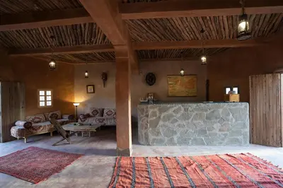 a living room with a stone wall and a couch at Lodge Hara Oasis in Agdz