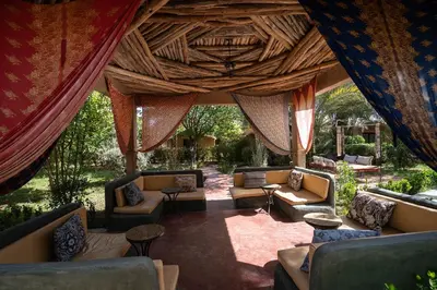 a living room with couches and chairs and a ceiling at Lodge Hara Oasis in Agdz