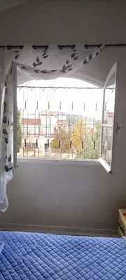 a bedroom with a bed and a large window at Quartier habri imouzzer kandar in Imouzzer Kandar