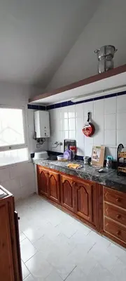 a kitchen with wooden cabinets and a counter top at Quartier habri imouzzer kandar in Imouzzer Kandar