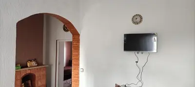 a room with a tv on the wall and a mirror at Quartier habri imouzzer kandar in Imouzzer Kandar