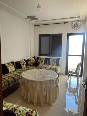 a living room with a couch and a table at très joli appartement a coté de l'airport fes in Oulad Tayeb