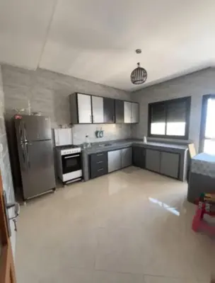 a kitchen with stainless steel appliances and black cabinets at très joli appartement a coté de l'airport fes in Oulad Tayeb