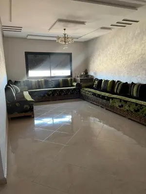 a living room with a couch and a chandelier at très joli appartement a coté de l'airport fes in Oulad Tayeb