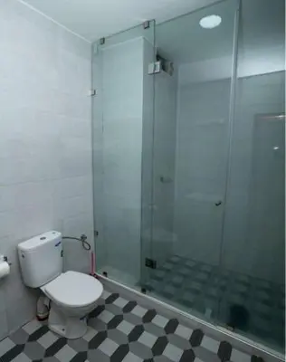 a bathroom with a toilet and a glass shower at Hotel OUM EL FADL in Fkih Ben Salah