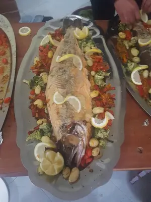 a plate of food with a fish and vegetables at Hotel OUM EL FADL in Fkih Ben Salah