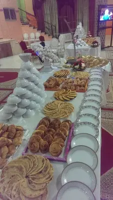 a long table with plates and pastries on it at Hotel OUM EL FADL in Fkih Ben Salah
