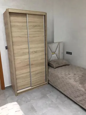 a bedroom with a large wooden closet next to a bed at AM Atlas Home in Ifrane