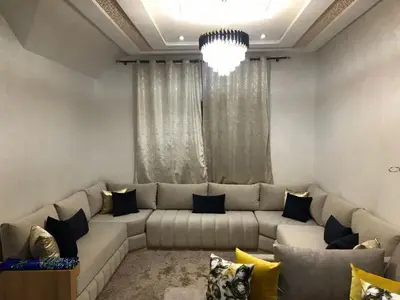 a living room with a large couch and a chandelier at AM Atlas Home in Ifrane