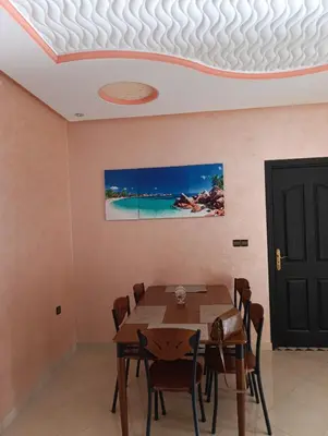 a dining room with a table and a tv on the ceiling at Mifatima in Mrhila