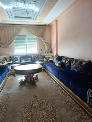 a living room with a blue couch and a table at Mifatima in Mrhila