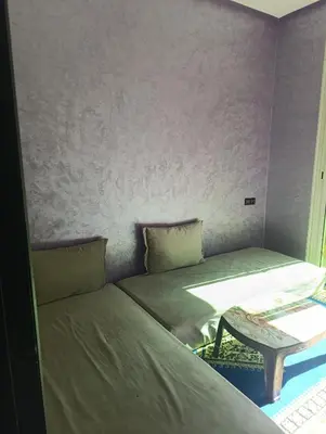 a small bedroom with a bed and a table at Mifatima in Mrhila