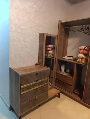a closet with a wooden dresser and a mirror at Mifatima in Mrhila