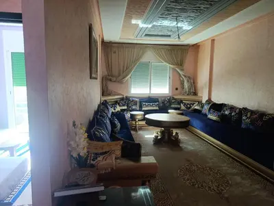 a living room with a blue couch and a table at Mifatima in Mrhila