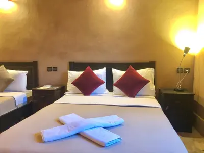 two towels on a bed in a hotel room at Kasbah Ennakb in Nkob