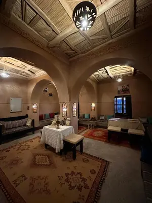 a large room with a table and couches in it at Kasbah Ennakb in Nkob