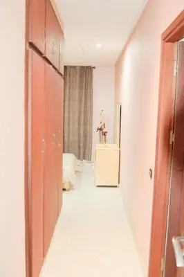 a hallway of a room with a bed and a dresser at Darkoum, your apartment in fes city in Fès